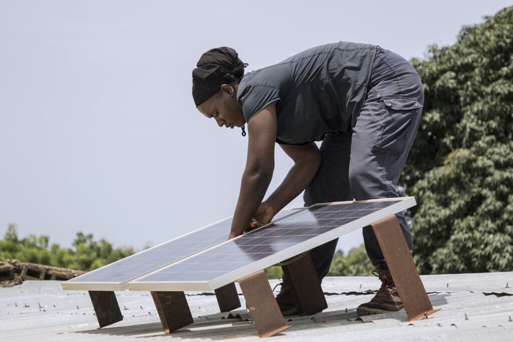 technician on roof assembles solar home panels